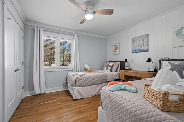 bedroom with wood finished floors, crown molding, and baseboards