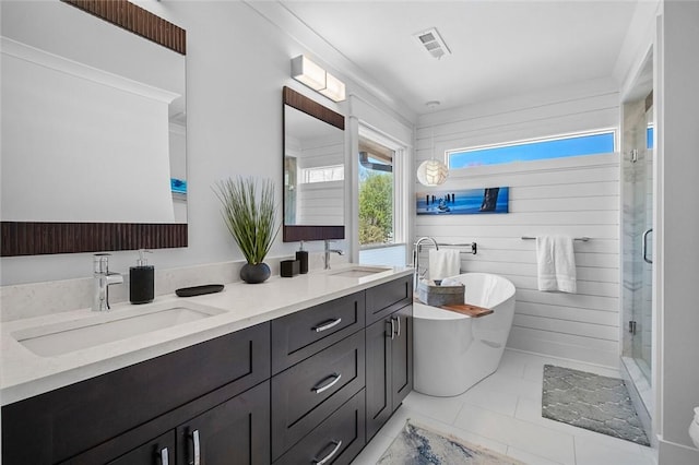 full bath featuring double vanity, a sink, visible vents, and a stall shower