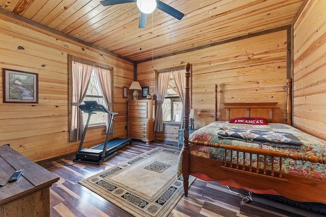 bedroom with wood finished floors, wooden ceiling, wooden walls, and multiple windows