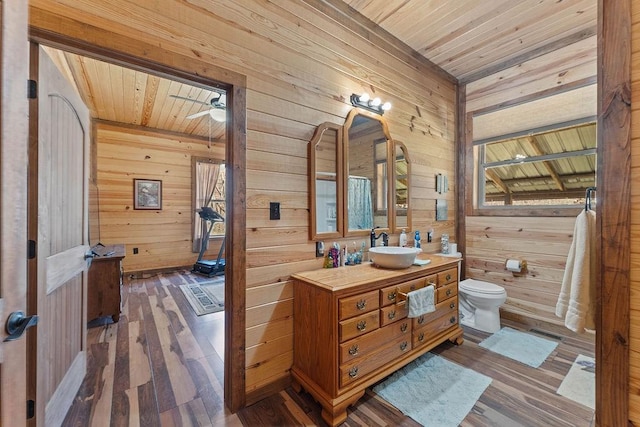 bathroom with toilet, visible vents, wood walls, wood ceiling, and hardwood / wood-style flooring