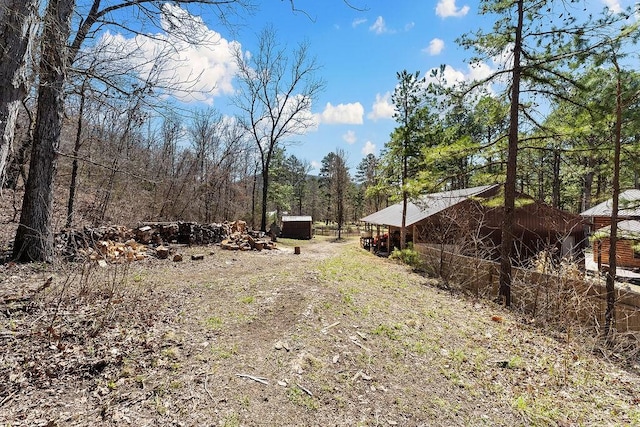 view of yard with an outdoor structure and a view of trees