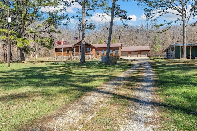 log home with a chimney, a front lawn, driveway, and an outbuilding