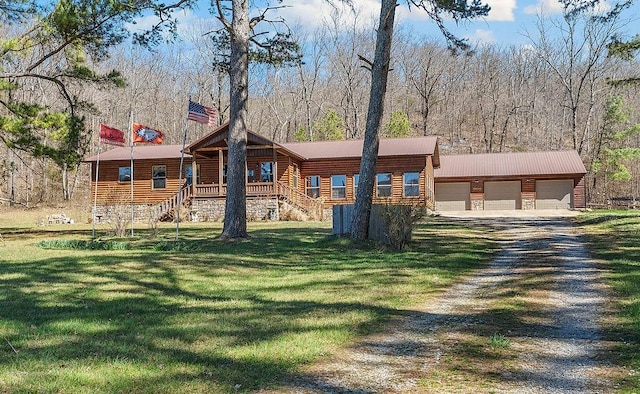 view of front facade with a front lawn, driveway, an outbuilding, and a detached garage
