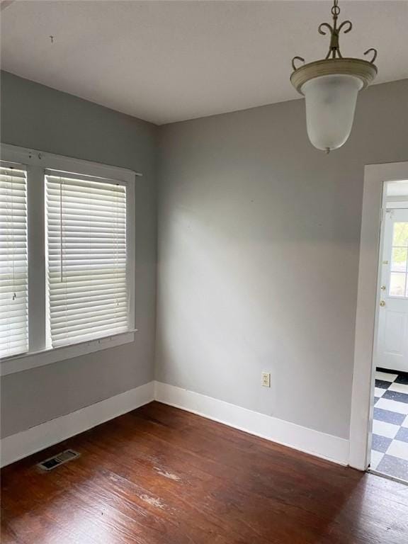 spare room featuring visible vents, wood finished floors, and baseboards