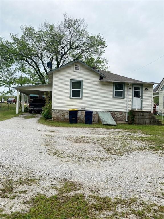 rear view of property with gravel driveway