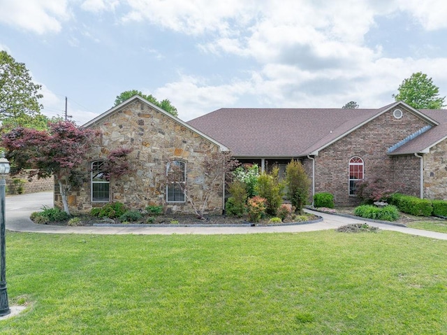 view of front of house with stone siding and a front yard
