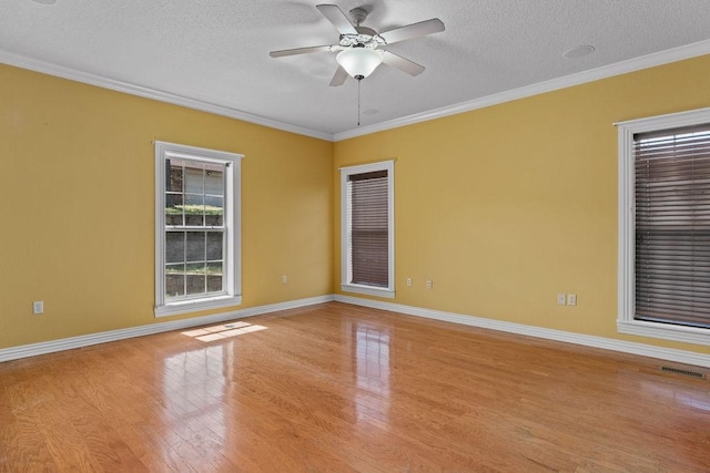 unfurnished room featuring baseboards, visible vents, wood finished floors, and a textured ceiling