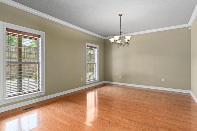 spare room with light wood-style floors, plenty of natural light, visible vents, and ornamental molding