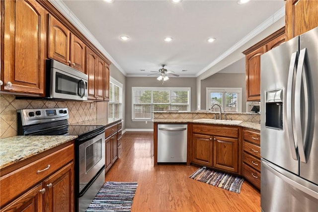 kitchen with recessed lighting, light wood-type flooring, appliances with stainless steel finishes, and a sink