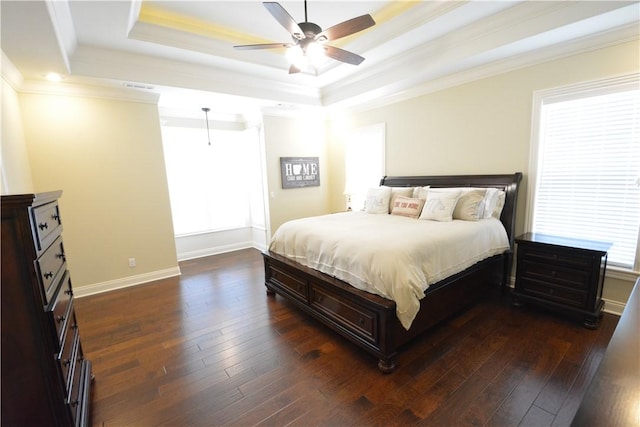 bedroom featuring visible vents, a tray ceiling, dark wood-type flooring, and crown molding