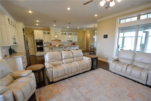 living area with crown molding, dark wood-style floors, and ceiling fan