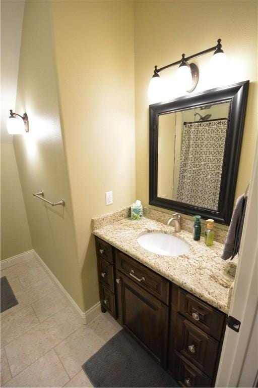 bathroom with baseboards, tile patterned floors, and vanity