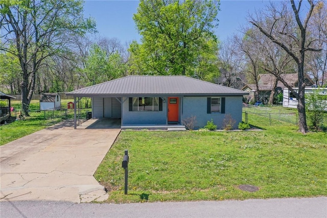 ranch-style home featuring driveway, metal roof, a carport, fence, and a front lawn