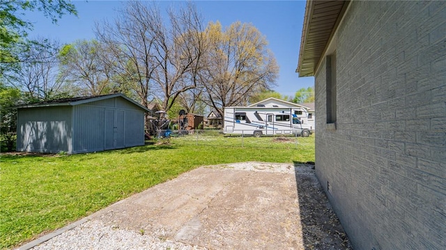view of yard with fence, an outbuilding, and a storage unit
