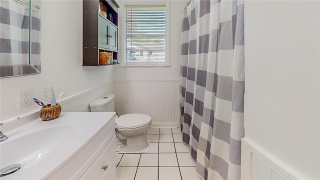 bathroom featuring a shower with curtain, wainscoting, vanity, tile patterned floors, and toilet