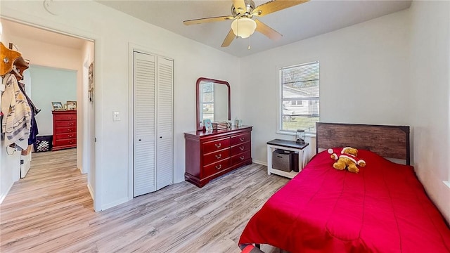 bedroom featuring a closet, light wood-style flooring, ceiling fan, and baseboards