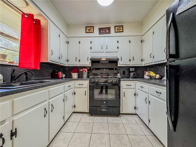 kitchen featuring dark countertops, a sink, black appliances, under cabinet range hood, and light tile patterned flooring