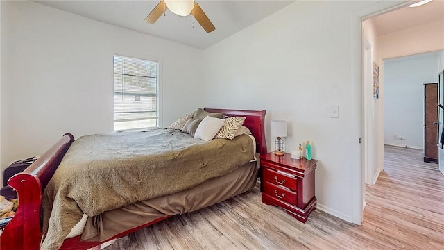 bedroom with baseboards, a ceiling fan, wood finished floors, and lofted ceiling