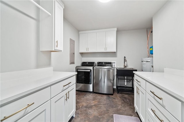 laundry area featuring separate washer and dryer, a sink, and cabinet space