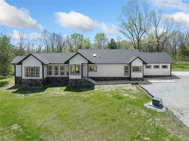 single story home with a front lawn, stone siding, and a shingled roof