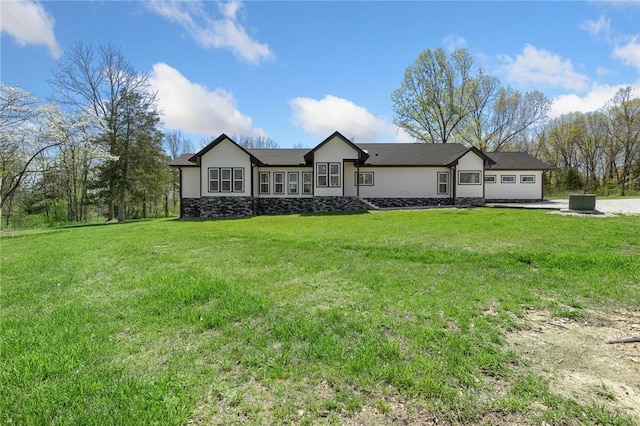 ranch-style house with stone siding and a front yard