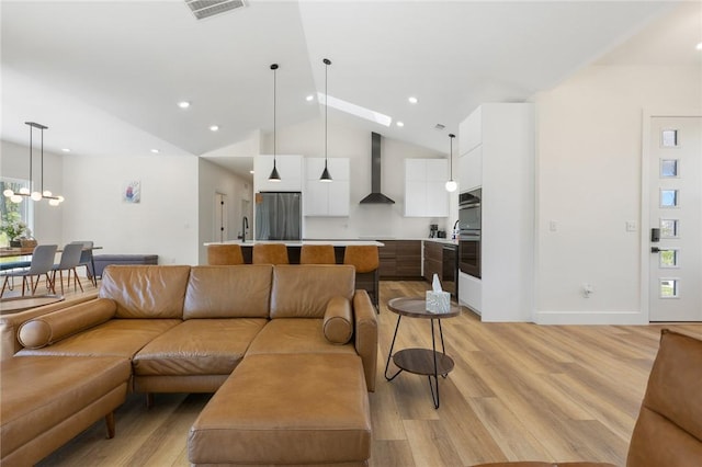 living area featuring recessed lighting, light wood-style floors, visible vents, and baseboards