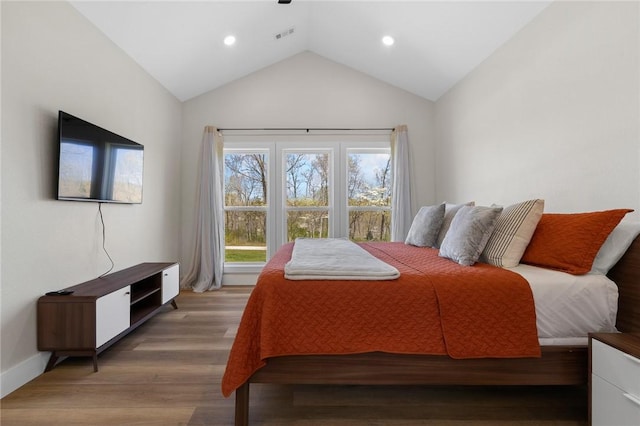 bedroom with vaulted ceiling, wood finished floors, baseboards, visible vents, and recessed lighting