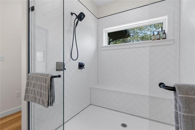 full bathroom with wood finished floors and tiled shower