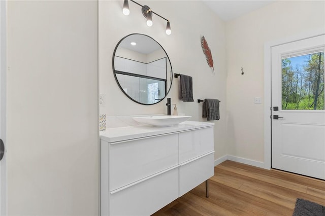 bathroom featuring baseboards, vanity, and wood finished floors