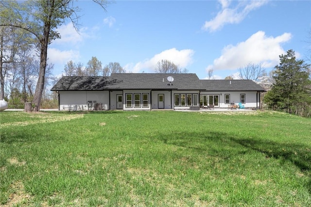 back of property with a lawn and a patio