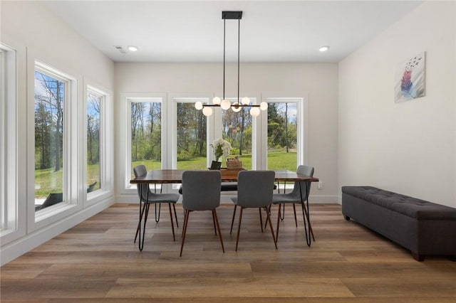 dining area with recessed lighting, light wood-style floors, and a notable chandelier