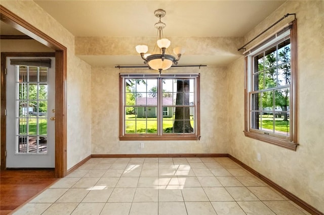 511 N Oakwood St, Lowell, AR 72745 - unfurnished dining area featuring baseboards, a chandelier, plenty of natural light, and light tile patterned floors