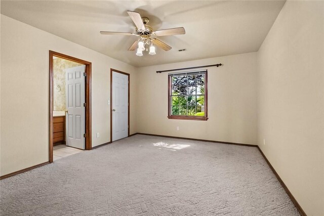 511 N Oakwood St, Lowell, AR 72745 - unfurnished bedroom with baseboards, visible vents, light carpet, and ensuite bathroom