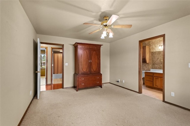 511 N Oakwood St, Lowell, AR 72745 - unfurnished bedroom with connected bathroom, a ceiling fan, baseboards, and light colored carpet