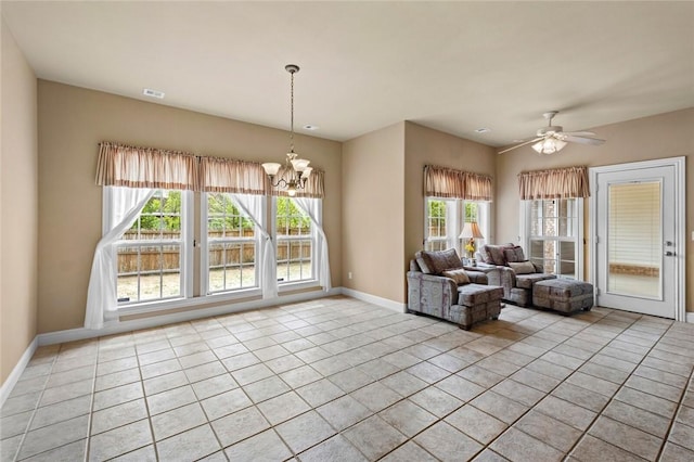 living area with baseboards, ceiling fan with notable chandelier, visible vents, and light tile patterned floors