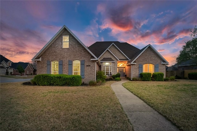 view of front of home featuring a front lawn and brick siding