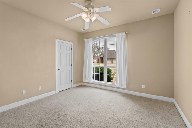 unfurnished room featuring ceiling fan, light carpet, visible vents, and baseboards
