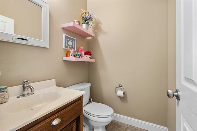 bathroom with baseboards, vanity, tile patterned flooring, and toilet