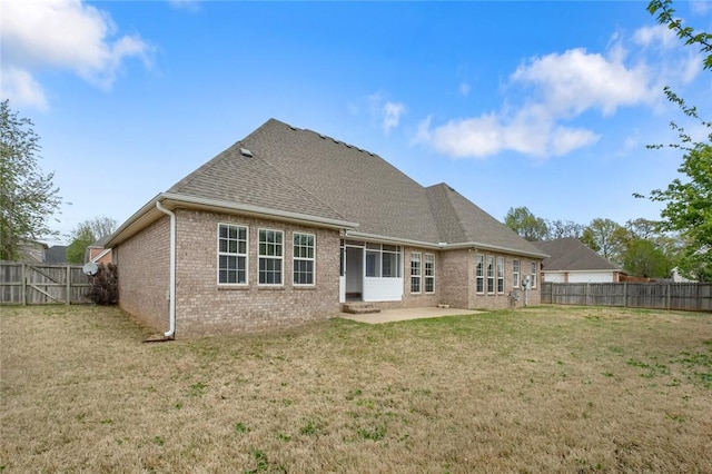 back of property featuring brick siding, a yard, a fenced backyard, and a patio