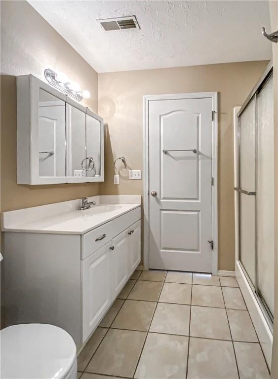 bathroom featuring a shower stall, visible vents, vanity, and tile patterned floors