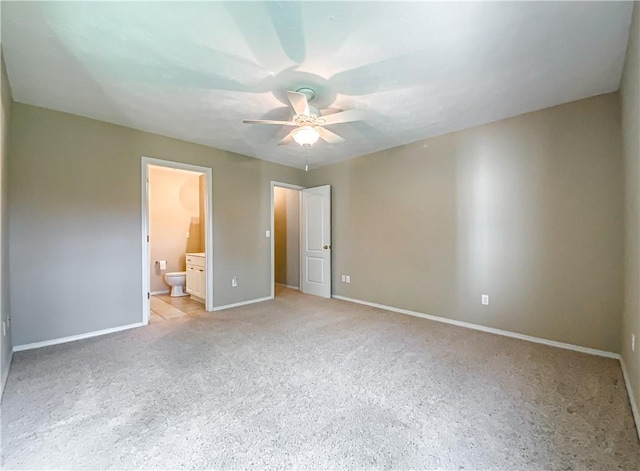 unfurnished bedroom with ensuite bath, a ceiling fan, baseboards, and light carpet