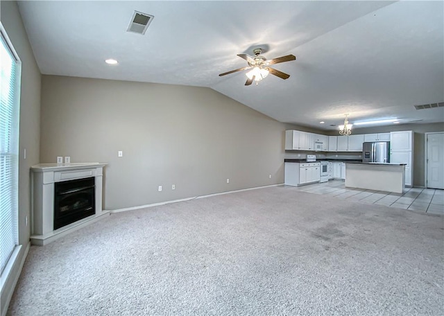 unfurnished living room featuring light carpet, baseboards, visible vents, a glass covered fireplace, and ceiling fan with notable chandelier