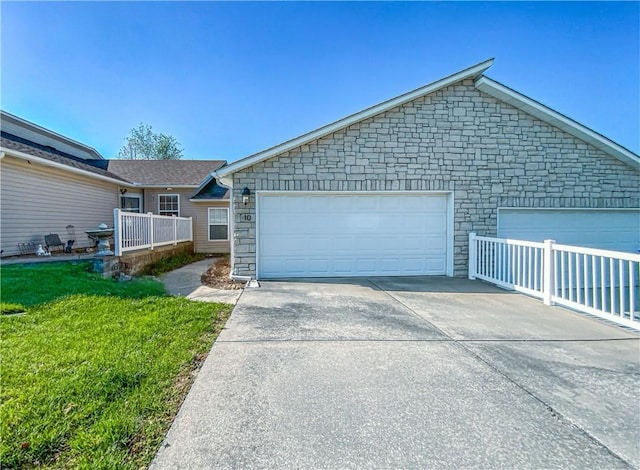 single story home featuring a front lawn, driveway, stone siding, and a garage