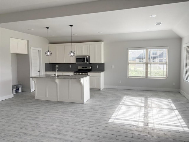 kitchen featuring light stone counters, stainless steel appliances, baseboards, decorative backsplash, and white cabinetry