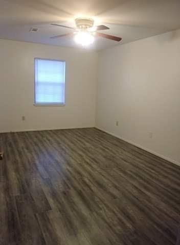 unfurnished room featuring dark wood-style floors and a ceiling fan