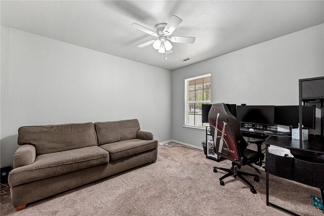 carpeted office featuring baseboards, a ceiling fan, and visible vents