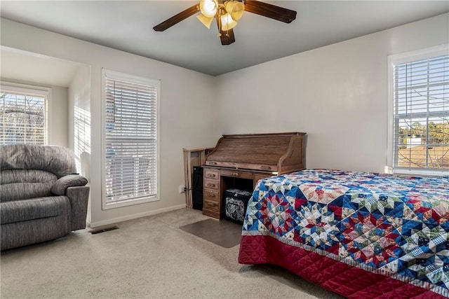 bedroom with ceiling fan, carpet floors, visible vents, and baseboards