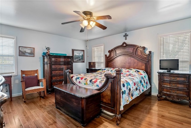 bedroom with wood finished floors, baseboards, and ceiling fan