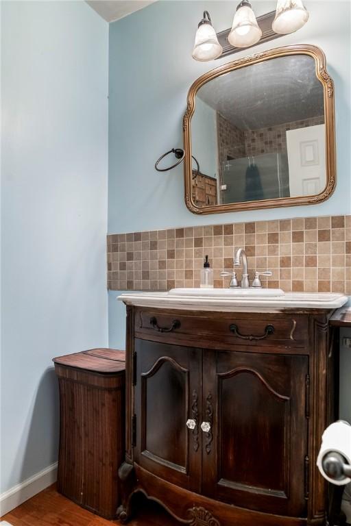 bathroom with backsplash, vanity, and a shower