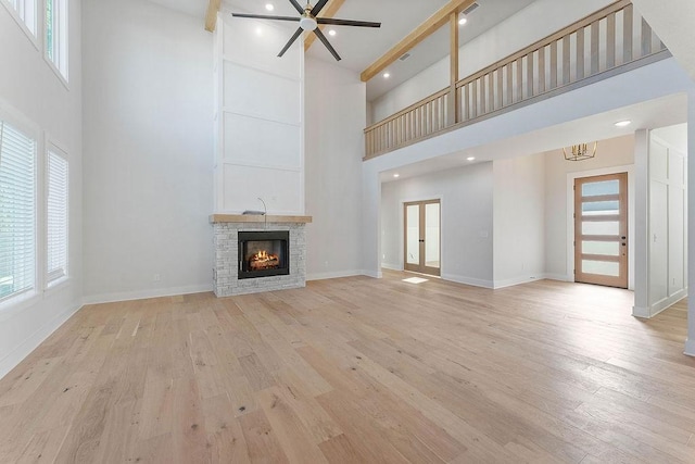 6416 S 59th St, Rogers, AR 72758 - unfurnished living room featuring a towering ceiling, plenty of natural light, light wood finished floors, and a ceiling fan